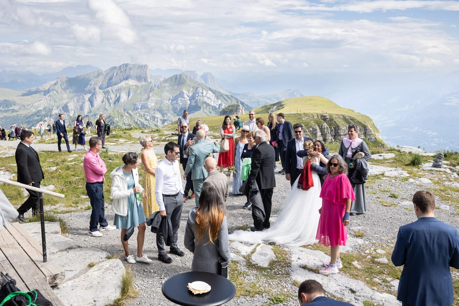 Gäste versammeln sich zum Apéro vor der Bergstation mit Blick auf die Alpen – Hochzeit auf dem Chäserrugg, fotografiert von Adrian Flütsch.